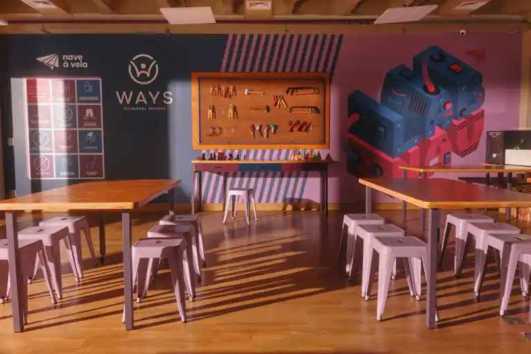 Laboratório maker da Ways, com bancadas, banquetas e um painel de ferramentas